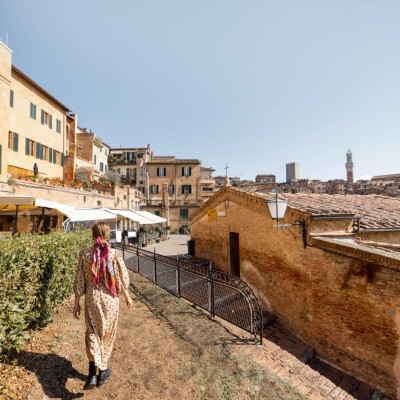 Mulher andando por uma antiga cidade italiana